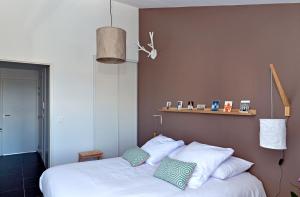 a bedroom with a bed with white sheets and pillows at Quintessens in Marseille