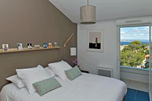 a bedroom with a white bed with a large window at Quintessens in Marseille