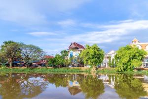 a group of buildings next to a body of water at Siem Reap Riverside Hotel in Siem Reap