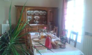 Maison Fleurie في Aubertin: طاولة طعام مع طاولة قماش بيضاء