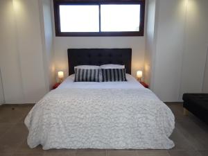 een slaapkamer met een groot wit bed met twee kussens bij Les Terrasses in Lavérune