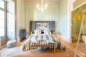 a bedroom with a bed and a chandelier at Charm Palace Porto in Porto
