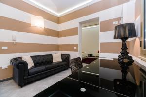 a living room with a black couch and a mirror at B&B Palazzo Diaz in Marsala