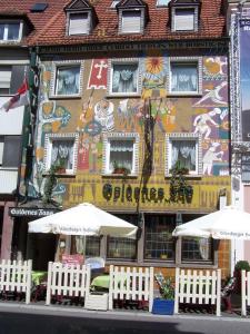 a building with white umbrellas in front of it at Hotel Goldenes Faß in Würzburg