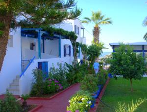 a white building with trees and plants in front of it at Porto Bello Hotel Apartments in Milatos
