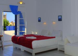 a bedroom with a bed with a red blanket at Porto Bello Hotel Apartments in Milatos