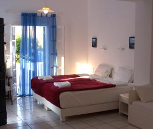 a bedroom with a bed with a red blanket at Porto Bello Hotel Apartments in Milatos