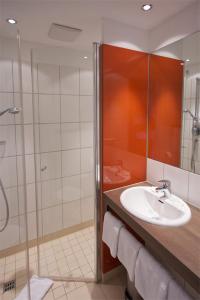 W łazience znajduje się umywalka i prysznic. w obiekcie iQ-Hotel Ulm w mieście Ulm