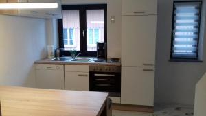 a kitchen with a sink and a stove and a window at Ferienwohnung Memil in Immenstadt im Allgäu