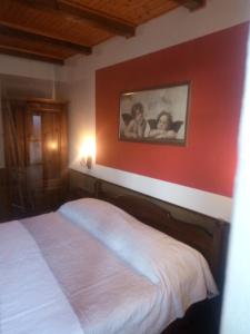 een slaapkamer met een bed met een rode muur bij Il Giardino di Marina in Santa Maria Maggiore