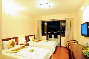 Postel nebo postele na pokoji v ubytování Ky Hoa Hotel Da Lat