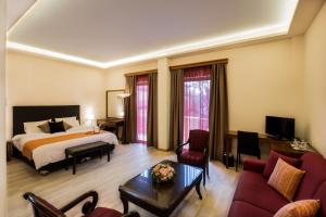 a hotel room with a bed and a living room at Rex Hotel in Nafplio