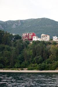 a group of houses on a hill next to the water at Palatino Hotel in Parga