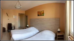 1 Schlafzimmer mit 2 Betten und einem großen Kopfteil in der Unterkunft Dolce Vita in Bruay-la-Buissiere