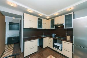 a kitchen with white cabinets and stainless steel appliances at Apartments on Henerala Zhmachenka in Kyiv