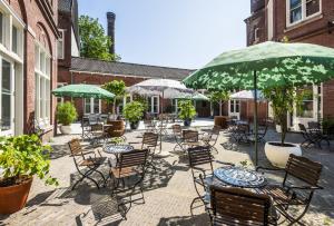 un patio avec des tables, des chaises et des parasols dans l'établissement Hotel Arena, à Amsterdam