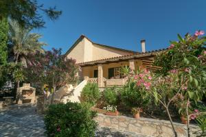 a house with flowers and plants in front of it at Marina's Villas in Vasilikos