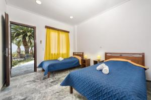 um quarto de hotel com duas camas e uma janela em Pavlimari Studios em Pyrgi Thermis