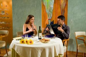 a man and woman sitting at a table with wine glasses at Termeterna Resort in Abano Terme