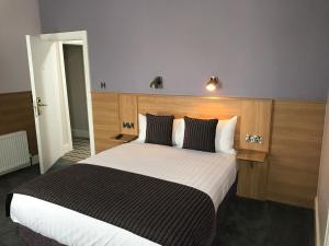 a bedroom with a large bed with a wooden headboard at Kennedys B&B Drumcondra in Dublin