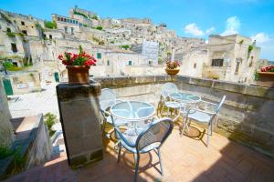 a patio with tables and chairs on a balcony at Sassolino Dimora Storica in Matera