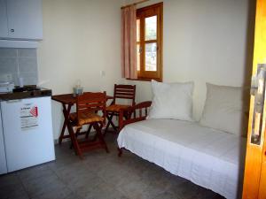 een slaapkamer met een bed en een tafel en een keuken bij Panorama Thea in Symi