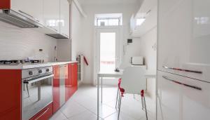 uma cozinha com armários vermelhos e brancos e uma cadeira branca em Italianway-Porro Lambertenghi em Milão
