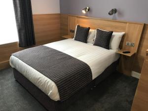 una camera con un grande letto con testiera in legno di Kennedys B&B Drumcondra a Dublino