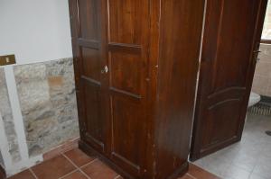 a wooden cabinet in a bathroom with a toilet at Residence Verde Blu in Fuscaldo