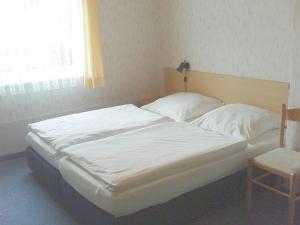 a bedroom with two beds with white sheets and a window at Gasthof zur Krone in Burghaslach