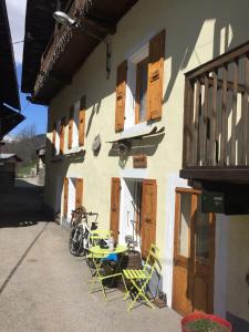 - une table et des chaises à l'extérieur d'un bâtiment avec un vélo dans l'établissement Chalet JJ, à Sainte-Foy-Tarentaise