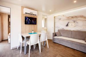 a living room with a table and a couch at Mobile Homes - FKK Nudist Camping Solaris in Poreč