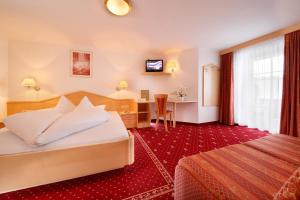 a hotel room with a bed and a desk at Hotel Alpenblick in Pfelders +32 photos