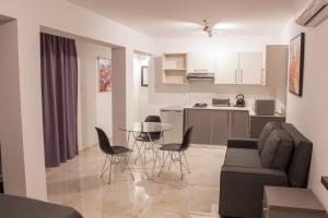 a living room with a couch and a table and chairs at Makronissos Beach Studio in Ayia Napa