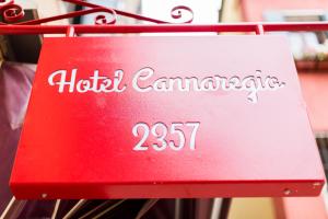 un cartello rosso per un hotel camambato su un appendiabiti di Hotel Cannaregio 2357 a Venezia