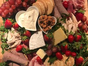 a plate of food with cheese and meat and fruit at Spa Suites at RAVEN in Hepburn Springs
