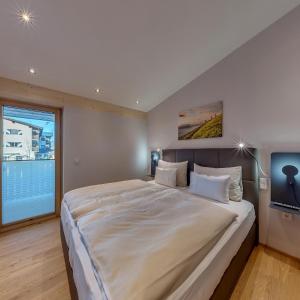 ein großes Bett in einem Zimmer mit einem TV in der Unterkunft das Stefan - Ferienwohnungen in den Kitzbüheler Alpen in Oberndorf in Tirol