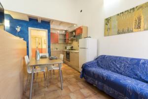 ボローニャにあるBertiera House by Studio Vitaの小さなアパートメントで、テーブルとソファが備わります。