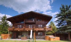 a large wooden house with a balcony on it at Chalet Des Sangliers in Séez