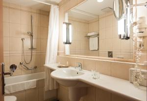 a bathroom with a sink and a shower and a mirror at Vitalmed Hotel Sárvár in Sárvár