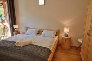 1 dormitorio con 1 cama grande y 2 lámparas en Aparthotel Kovarna Residence, en Pec pod Sněžkou