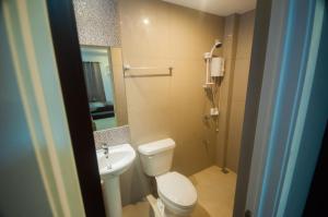 bagno con servizi igienici bianchi e lavandino di NF Suites a Davao
