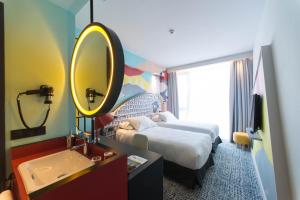 a bedroom with a bed and a mirror at ibis Styles Tbilisi Center in Tbilisi City