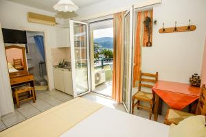 a room with a bed and a kitchen with a balcony at Myros Studios in Argostoli