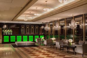 una hall con lampadari a braccio e parete verde di Hotel Plumm a Yokohama