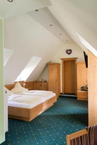 ein Schlafzimmer mit einem großen Bett im Dachgeschoss in der Unterkunft Hotel zur Post in Blieskastel