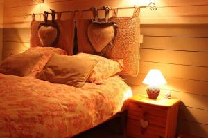a bedroom with a bed and a nightstand with a lamp at Gite Le Paradis in Saint-Nabord