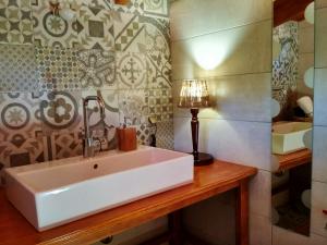 a bathroom with a sink and a lamp on a wooden counter at Oresivio in Metsovo