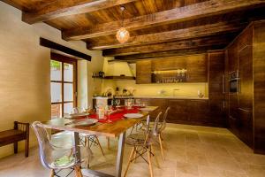 eine große Küche mit einem Holztisch und Stühlen in der Unterkunft Casa Ulivo in Tar