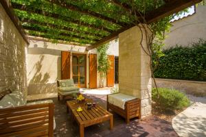 eine Terrasse mit einem Sofa, einem Tisch und einem Stuhl in der Unterkunft Casa Ulivo in Tar